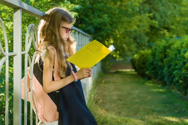 Studentessa Scuola Elementare Indossando Occhiali Con Zaino Legge Taccuino Scolastico — Foto Stock