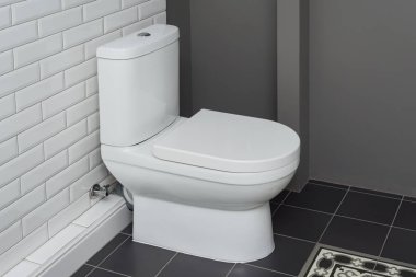 White ceramic toilet bowl in the bathroom interior close-up. clipart