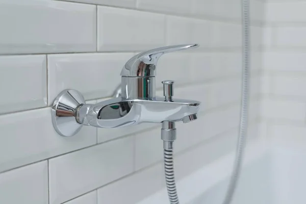 クロム シャワー 浴室での蛇口のクローズ アップ カバー白い光沢のあるレンガと装飾的なセラミック タイル — ストック写真