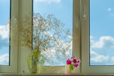 Window in apartment, house, view of blue sky with clouds. On the windowsill vase of flowers, home real life clipart