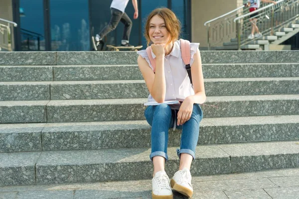 14岁的女学生的户外肖像 年轻女孩与背包 坐在台阶在她的手举行学校笔记 — 图库照片