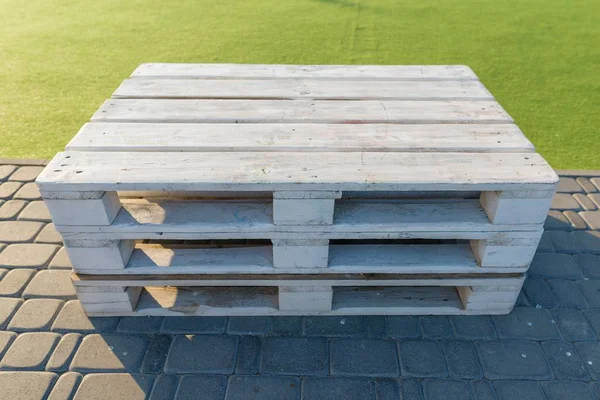 Wooden modern outdoor furniture assembled from pallets, painted white in recreation and entertainment zone