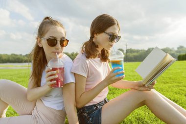 Yaz güneşli bir gün, gençler yeşil çimenlerin üzerine oturmak, kokteyl içmek, konuşmak, kitap okumak, gülmek, eğlenmek iki kız arkadaşım