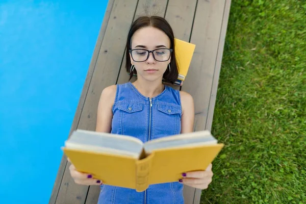 Tienermeisje Glazen Leest Een Boek Achtergrond Zwembad Het Gazon Buurt — Stockfoto