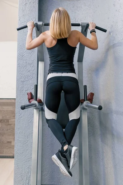 Kobiety Fitness Ćwiczenia i robi pull-up w siłowni, widok z tyłu. Sport, sportowiec, szkolenia, zdrowego stylu życia i koncepcja ludzie — Zdjęcie stockowe