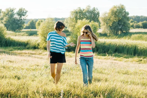 幸せママと十代の娘の笑顔でお返事。日当たりの良い夏の日に自然の中を歩いてください。 — ストック写真