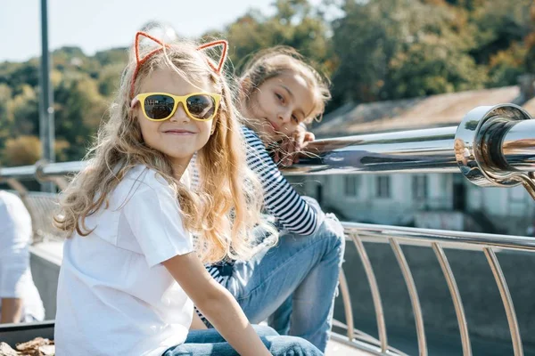 Außenporträt von zwei kleinen schönen Mädchen, die an einem sonnigen Sommertag lächeln — Stockfoto