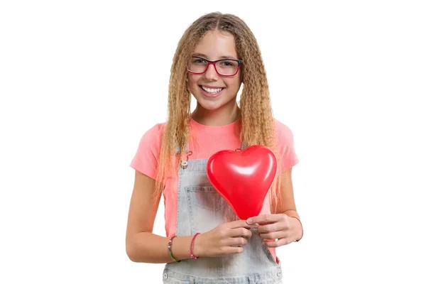 Jeune adolescente souriante félicitant pour les vacances avec ballon coeur rouge sur fond blanc isolé — Photo