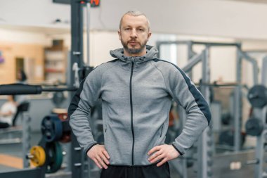 Spor Salonu, fitness eğitmeni kameraya bakarak çapraz yakışıklı sportif adam portresi