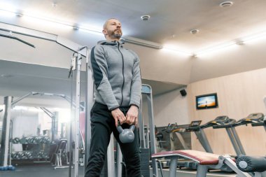 Yakışıklı yetişkin spor salonunda fiziksel egzersizleri yapıyor adam sakallı. Spor rehabilitasyon, yaş, sağlıklı yaşam konsepti.