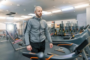 Yakışıklı yetişkin spor salonunda fiziksel egzersizleri yapıyor adam sakallı. Spor rehabilitasyon, yaş, sağlıklı yaşam konsepti.