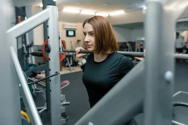 Joven mujer de fitness fuerte haciendo ejercicios de fuerza con pesadas pesas en el gimnasio deportivo. Deporte, levantamiento de pesas, musculación, entrenamiento, estilo de vida y concepto de personas — Foto de Stock