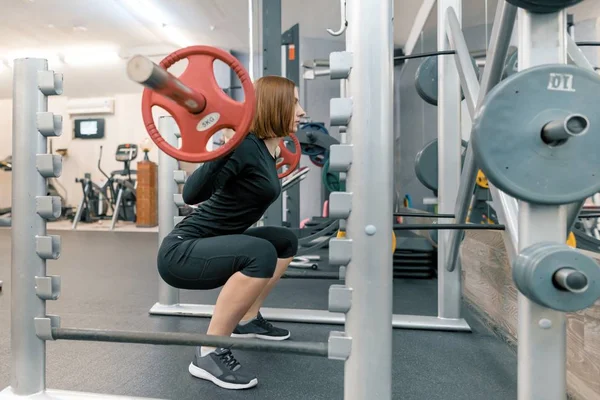 Erős, fiatal nő csinál nagy súlyú edzhetnek az edzőteremben. Sport, fitnesz, testépítés, képzés, életmód és az emberek koncepció — Stock Fotó