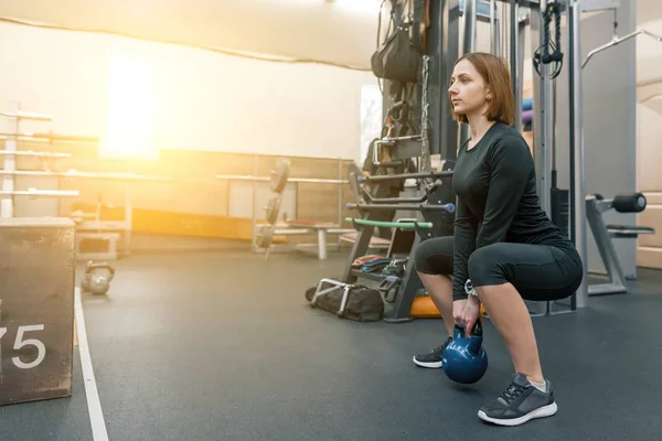 Entrenamiento joven fuerte de la mujer de la aptitud con pesos pesados en gimnasio de la aptitud. Deporte, fitness, musculación, entrenamiento, estilo de vida y concepto de personas — Foto de Stock