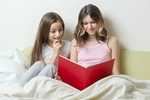 Δύο έφηβες που κάθεται στο σπίτι στο κρεβάτι Κοιτάξτε στο σχολικό τετράδιο. Επικοινωνίας και μάθησης στο σπίτι — Φωτογραφία Αρχείου