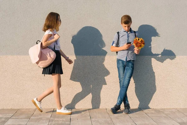 Retrato al aire libre de adolescentes, niño con ramo de flores y niña, fondo de pared gris — Foto de Stock