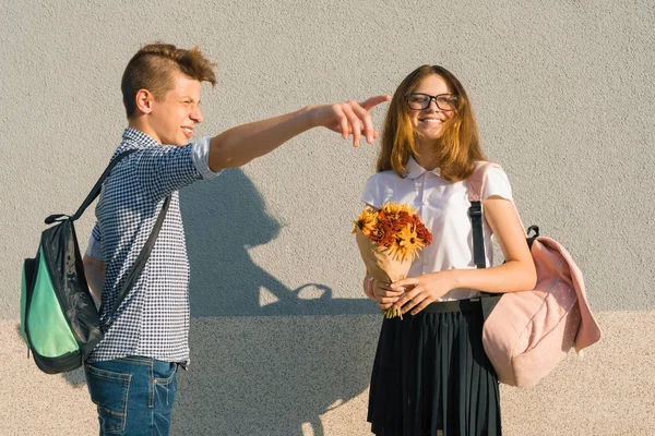 Ein paar Teenager gehen, lachen, reden, Mädchen mit Blumenstrauß — Stockfoto