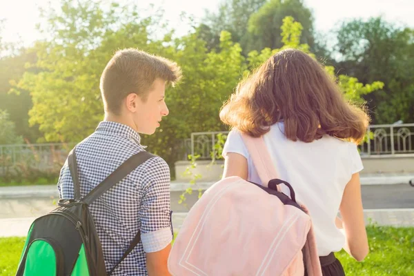 Niños adolescentes van a la escuela, vista trasera. Al aire libre, adolescentes con mochilas — Foto de Stock