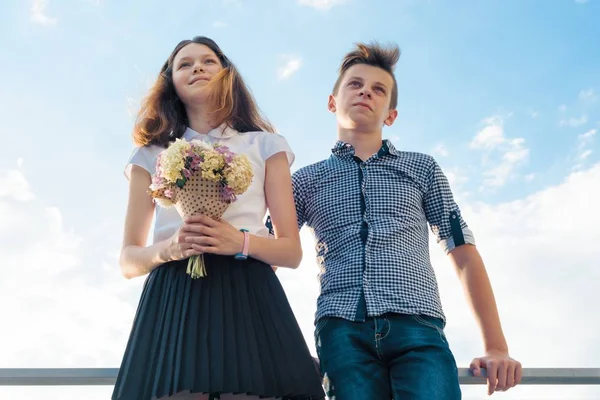Boldog pár tizenéves fiú és lány, 14, 15 éves. A fiatalok mosolyogva, és beszél, a kék ég háttér — Stock Fotó