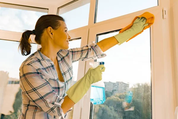 Servicio de limpieza profesional. Mujer ama de llaves limpiando ventanas — Foto de Stock