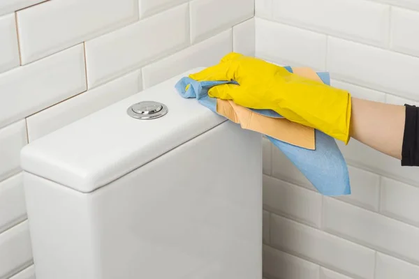 Les mains de la femme en gants de protection en caoutchouc jaune lavent les toilettes — Photo