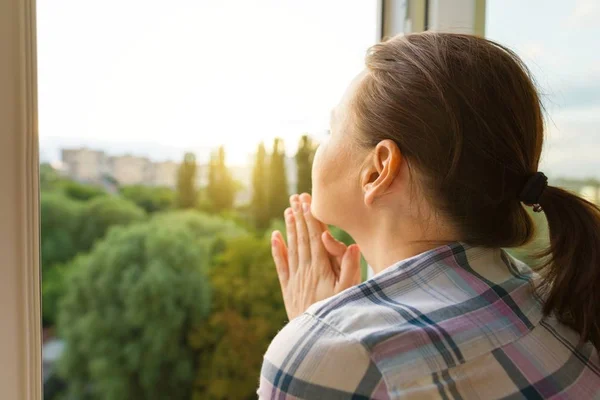 Rijpe vrouw keek uit het raam, close-up uitzicht vanaf de achterkant — Stockfoto