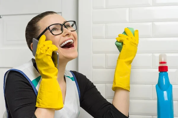 Huisvrouw vrouw is het reinigen in de badkamer en lacht praten aan de telefoon. — Stockfoto