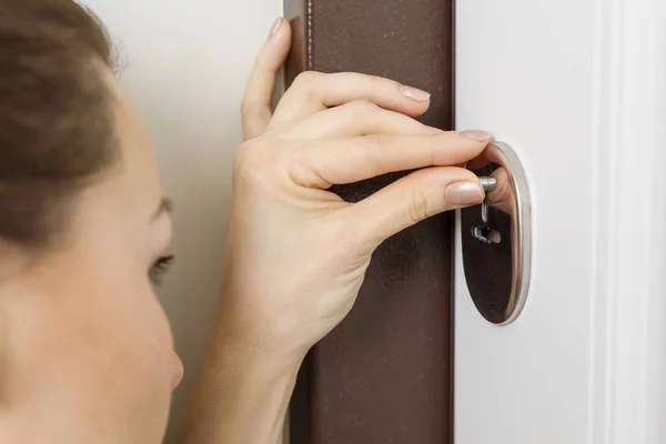 Woman peeks looks into the hole of the door lock — Stock Photo, Image