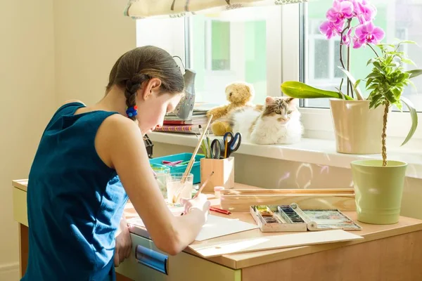 Chica adolescente dibuja acuarela, sentado en casa en la mesa. Creatividad infantil, recreación, desarrollo —  Fotos de Stock