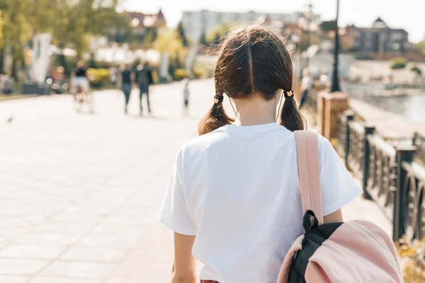 Nastoletnią student dziewczyna idąc ulicą z plecaka. Powrót do szkoły widok z tyłu — Zdjęcie stockowe