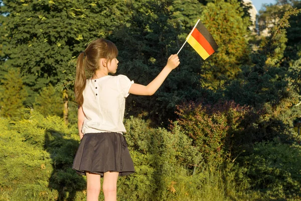 Petite étudiante tenant un drapeau de l'Allemagne, dans le parc, dos , — Photo