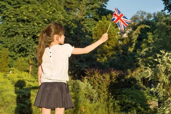 Liten flicka med flagga av Storbritannien i hennes hand, i soliga sommaren park — Stockfoto