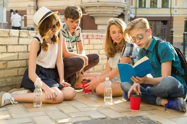 Feliz 4 amigos adolescentes ou estudantes do ensino médio lendo livros. Conceito de amizade e pessoas — Fotografia de Stock