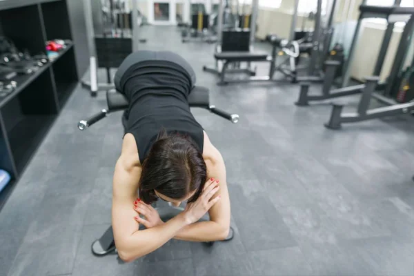 Joven hermosa mujer atlética morena haciendo ejercicios de fitness en el gimnasio. Fitness, deporte, entrenamiento, personas, concepto de estilo de vida saludable . — Foto de Stock