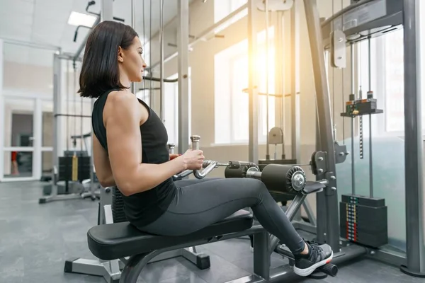 Giovane bella donna atletica bruna che fa esercizi di fitness in palestra. Fitness, sport, allenamento, persone, concetto di stile di vita sano . — Foto Stock