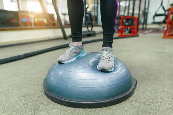 Piernas de mujer fitness en zapatillas de primer plano en el gimnasio, mujer haciendo ejercicios. Fitness, deporte, entrenamiento, personas, concepto de estilo de vida saludable . — Foto de Stock