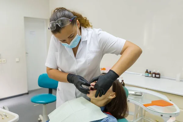 Доросла жінка-стоматолог лікує зуби пацієнтки. Медицина, стоматологія та концепція охорони здоров'я — стокове фото