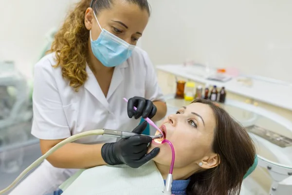 Dentista mujer adulta tratando dientes de mujer paciente. Medicina, odontología y concepto sanitario — Foto de Stock