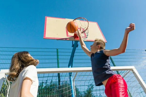 Streetball basketball game with two players, teenagers girl and boy, morning on basketball court — Stock Photo, Image