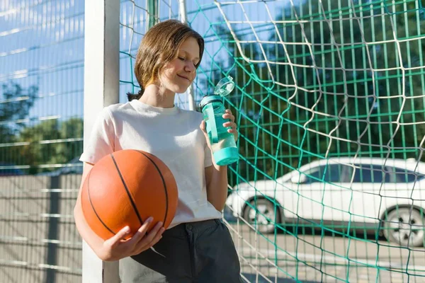Tinédzser lány kosárlabdázni, a labda a kosárlabda bírósági ivóvíz — Stock Fotó
