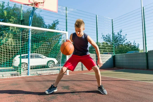 Adolescente chico calle jugador de baloncesto en la cancha de baloncesto de la ciudad — Foto de Stock