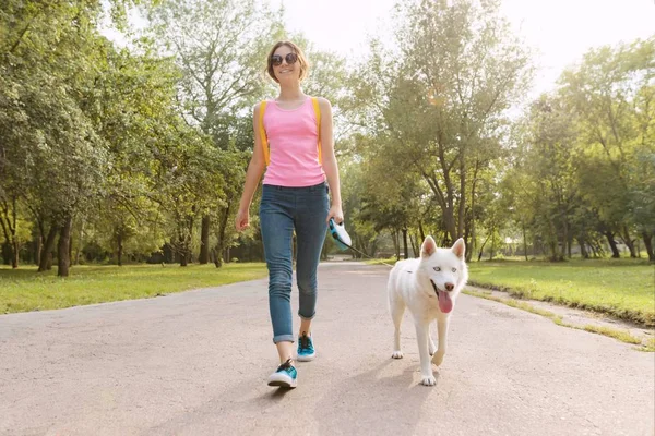 Jeune adolescente marchant avec un chien dans le parc — Photo