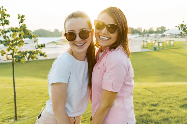 Portrait de maman heureuse et fille adolescente. Parent et enfant embrassent et sourient en marchant un jour d'été, heure d'or, week-end ensemble — Photo