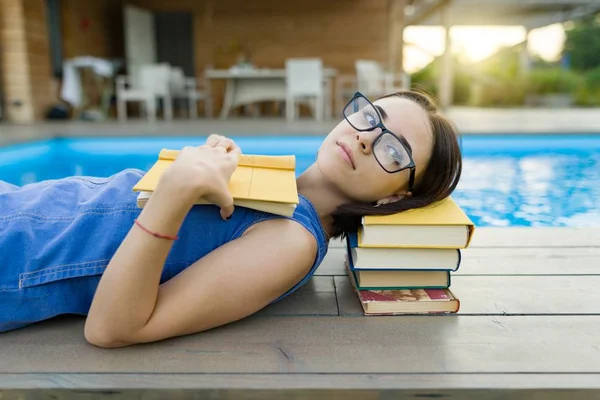 Schattig student meisje lezen boek liggen in de buurt van het zwembad. Onderwijs, zomer, kennis — Stockfoto