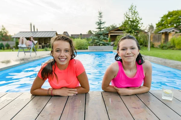 Dos jóvenes adolescentes divirtiéndose en la piscina, sonriendo mirando a la cámara — Foto de Stock