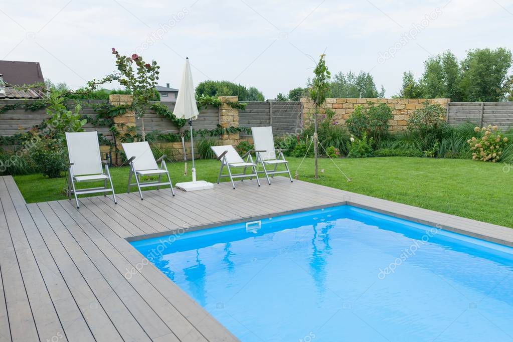 Outdoor swimming pool on private residence, lawn, garden.