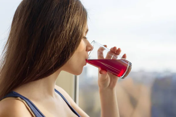 Jeune femme buvant du jus naturel de baies fraîches dans un verre, gros plan — Photo