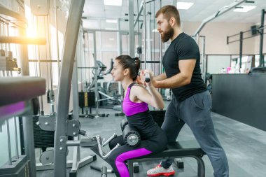 Koçluk ve istemci kadın yapma egzersiz jimnastik salonu yardım kişisel fitness eğitmeni. Eğitim, spor, takım çalışması, insanlar kavramı.