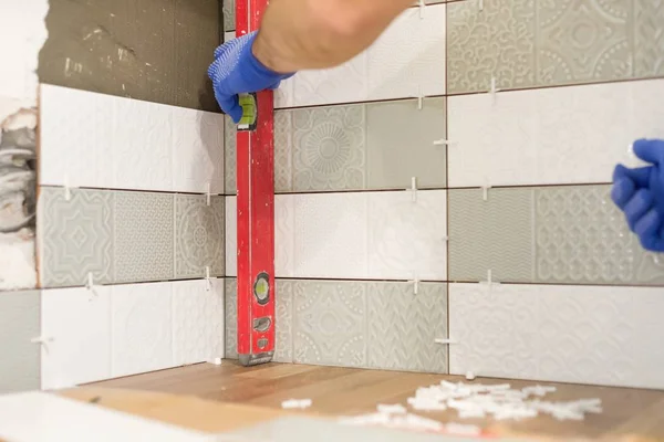 Réparation et construction de la cuisine, les mains de carrelage installation de carreaux de céramique sur le mur, utiliser des outils professionnels, véritable processus de pose — Photo