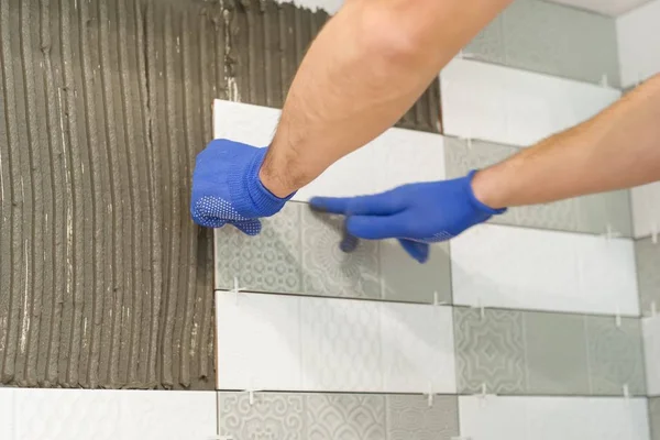 Primer plano de la mano de tiler colocación de baldosas de cerámica en la pared en la cocina, renovación, reparación, construcción — Foto de Stock